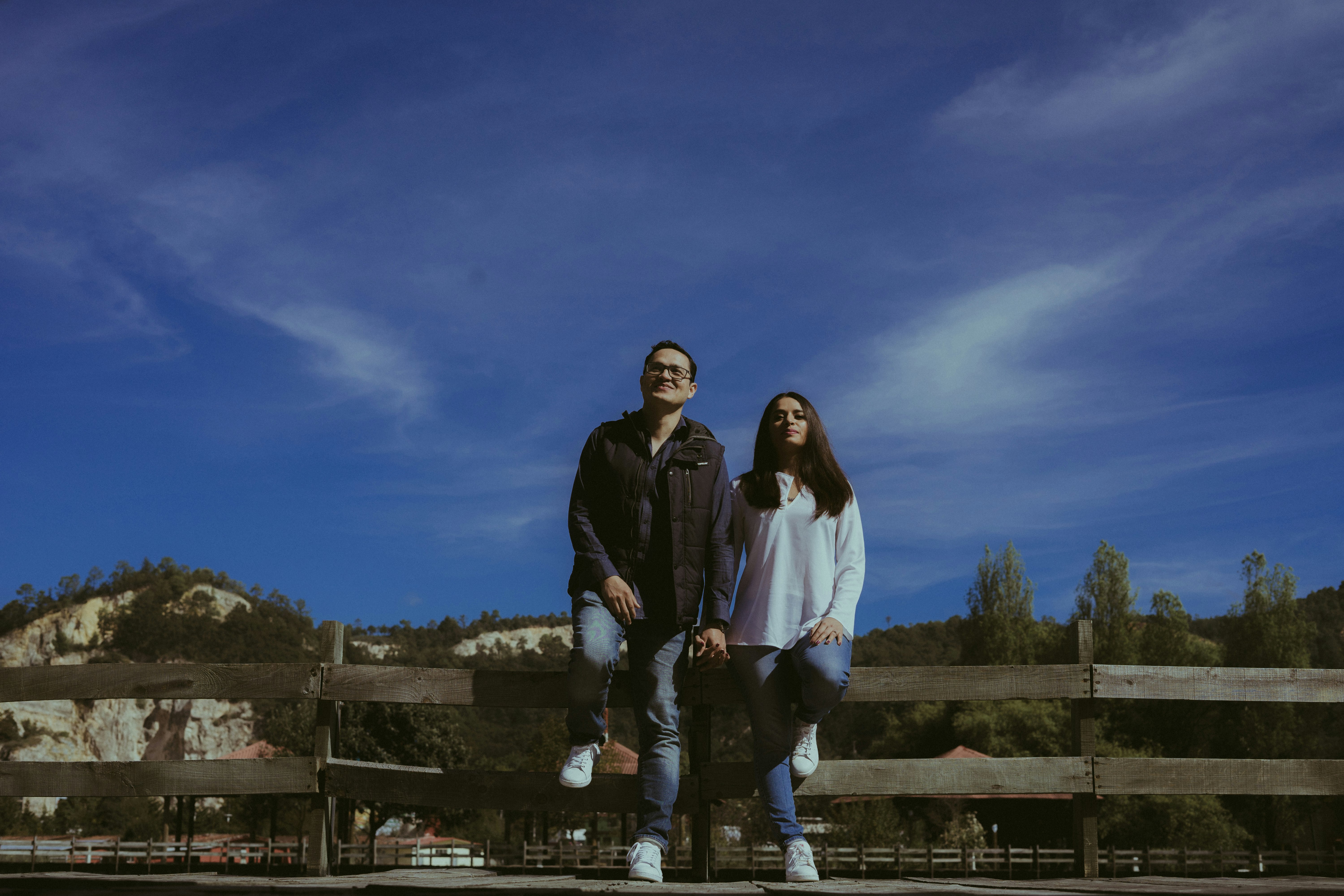 man and woman standing on gray concrete pavement during daytime